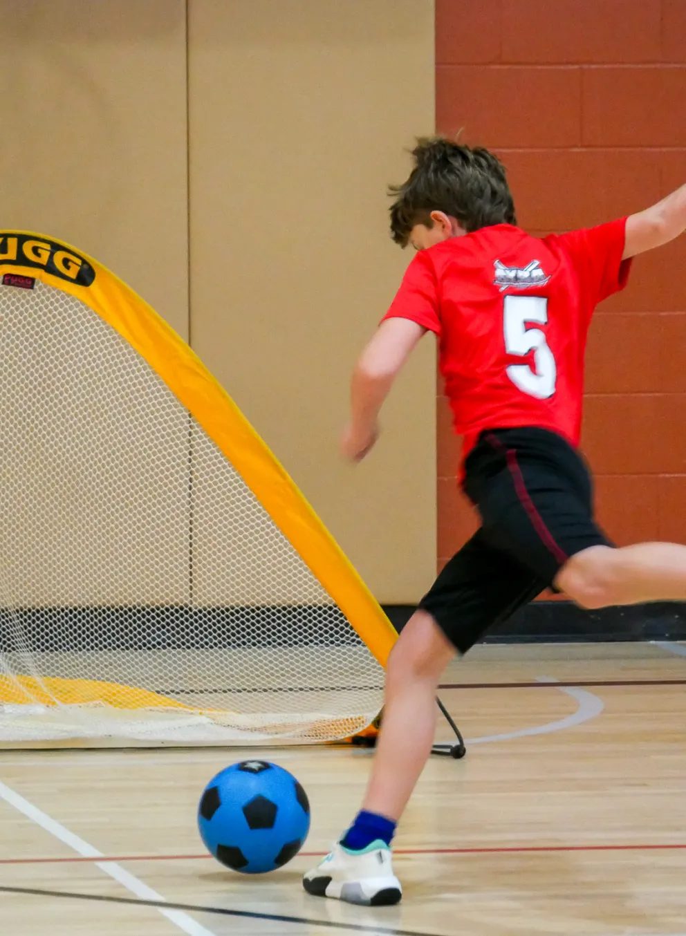 child kicking a soccer ball