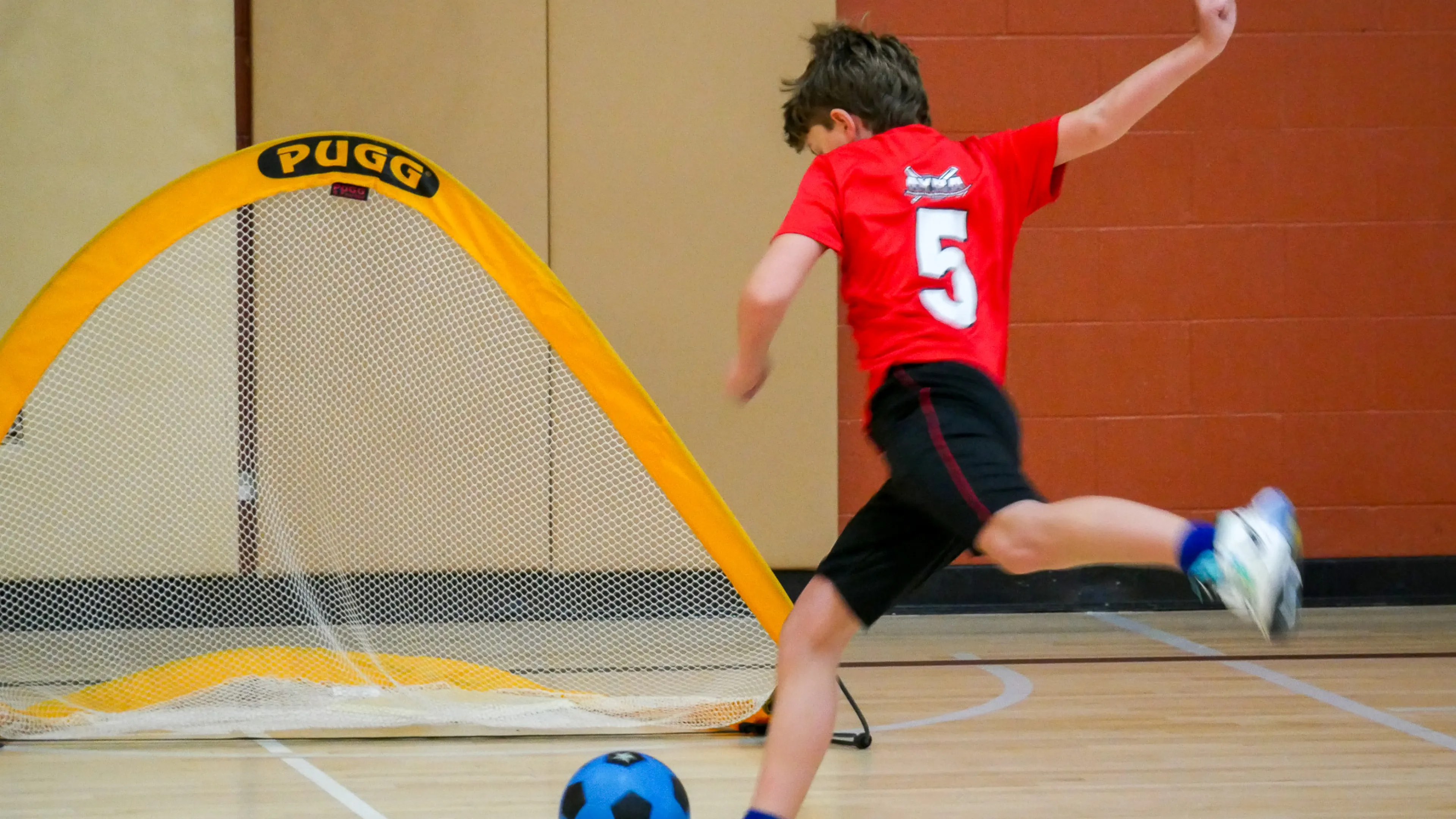 child kicking a soccer ball